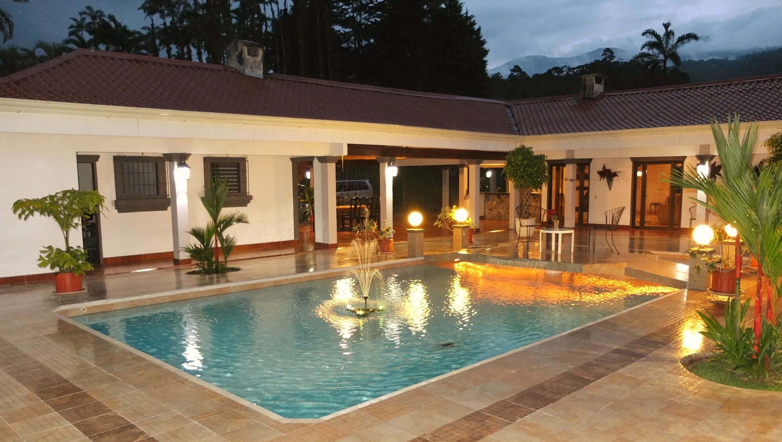 The hacienda's colonial courtyard and illuminated pool at dusk
